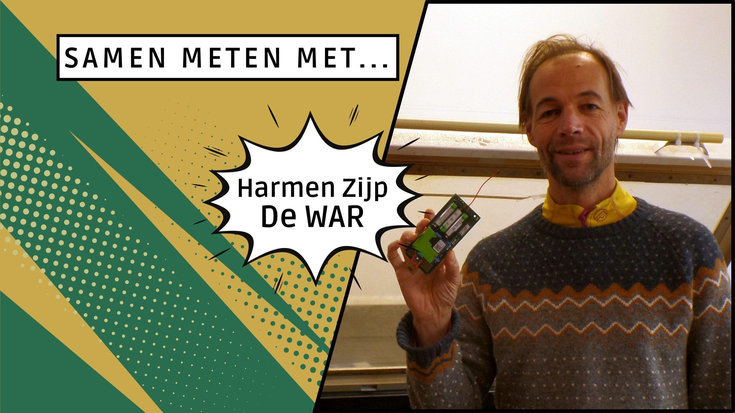 Egon Kastelijn die vrolijk lacht en een meetkastje ophangt